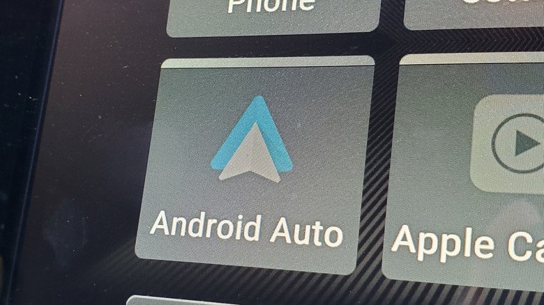 An enlarged car screen with the Android Auto  and Apple CarPlay app icons visible