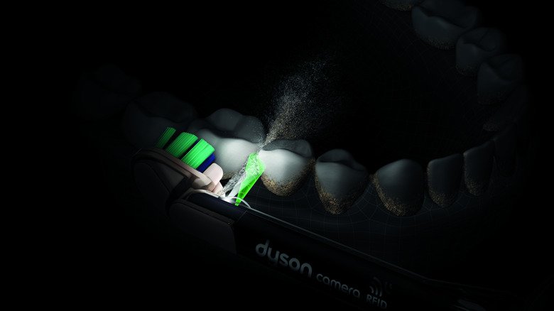 A close up of the Dyson CameraJet squirting water into the gap between teeth.