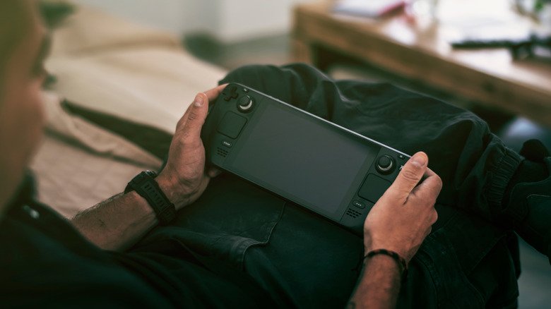 Man sitting with a Steam Deck in his hands.