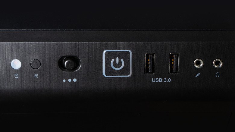 A desktop PC's power button, alongside various ports.